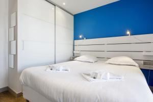 ビアリッツにあるAppartement Barbeau - Welkeysの白いベッドとタオルが2枚置かれた寝室
