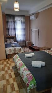 a hotel room with two beds with towels on them at Hotel Central in Kutaisi