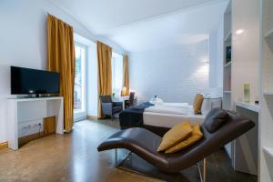 a hotel room with a bed and a leather chair at Vienna Residence, City Hall - Parliament in Vienna
