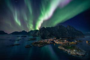 an aerial view of an island under the northern lights at Villa Bryggekanten - by Classic Norway Hotels in Henningsvær