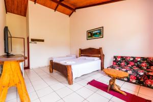 een slaapkamer met een bed en een bank bij Hotel Fazenda Serra da Irara in Corumbá de Goiás