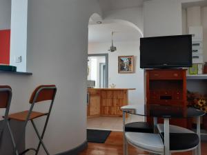 a living room with a table and a television at L'ère du temps in Manheulles