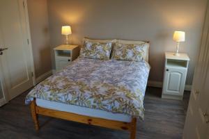 a bedroom with a bed with two night stands and two lamps at Mount Alohert House in Killarney