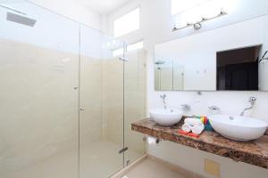 a bathroom with two sinks and a glass shower at Hotel Boutique Casa Mar in Cartagena de Indias