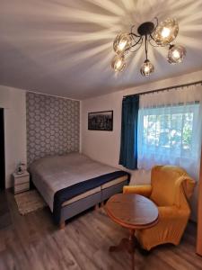 a bedroom with a bed and a table and a chair at Apartament Ogrodowa in Frombork