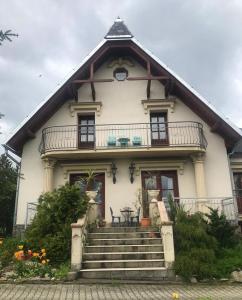 a large white house with a balcony and stairs at Vila pod Ještědem in Liberec