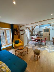 sala de estar con sofá azul y mesa en Au Cheval Blanc - appartements et chambres d'hôtes, en Albertville