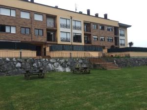 ein Gebäude mit zwei Picknicktischen davor in der Unterkunft La Tilar, apartamento con gran terraza a 3 km de la playa in Llanes