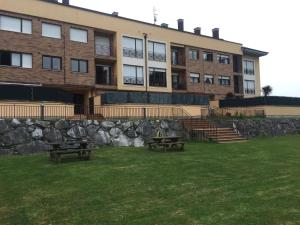 a building with two picnic tables in front of it at La Tilar, apartamento con gran terraza a 3 km de la playa VUT-2574-AS in Llanes