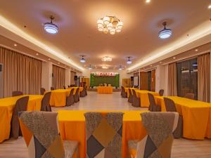 un gran salón de banquetes con mesas y sillas amarillas en Jurias Garden Hotel, en El Nido