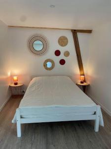 - un lit blanc dans une chambre avec deux lampes dans l'établissement Domaine du Bû sur Rouvres, à Le Bû-sur-Rouvres