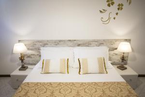 a bedroom with a white bed with two lamps at Ca' Berenice - Biennale in Venice