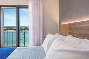 a bedroom with a bed with a view of the water at Hotel Montemar *** Superior in O Grove