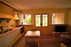 a kitchen with a sink and a table with chairs at les jardins de la sud in Lacanau
