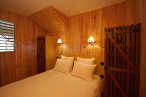 a bedroom with a bed and a wooden wall at les jardins de la sud in Lacanau