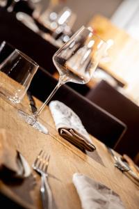 einen Tisch mit einem Weinglas und Küchenutensilien darauf in der Unterkunft restaurant271 in Burghausen
