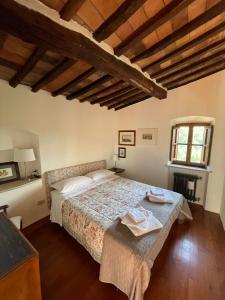 um quarto com uma cama num quarto com tectos em madeira em Casa vicolo dell’assedio em Pitigliano