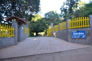 a road with a yellow fence with a sign on it at Pousada Lakshmi in Vale do Capao