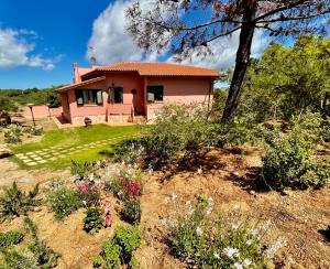 een huis op een heuvel met bloemen in de tuin bij Sera & Mattino Appartamenti by SolturElba in Capoliveri