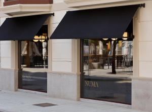 a store front with two black awnings on the windows at NUMA HOTEL BOUTIQUE in Gijón