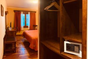 a room with a bedroom with a bed and a microwave at Patagonia Queen Hotel Boutique in El Calafate