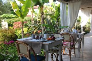 due tavoli e sedie con frutta su un patio di Hotel Bijou a Forte dei Marmi