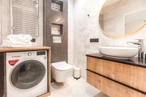 een badkamer met een wasmachine en een wastafel bij Kristina Apartments Sopot in Sopot