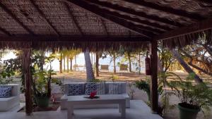 a patio with a white table and chairs under a pavilion at Oceano Atins in Atins