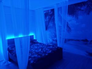 a bedroom with a bed with a blue light at Iași Jacuzzi Apartment F in Iaşi