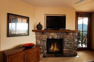 salon z kominkiem i telewizorem z płaskim ekranem w obiekcie Purgatory Lodge Unit 403 w Durango Mountain Resort