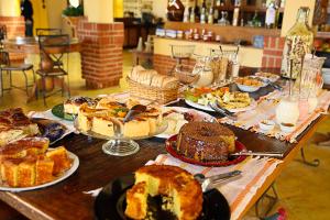 uma mesa cheia de diferentes tipos de bolos e tortas em Villa D'Ouro Pousada em Tiradentes