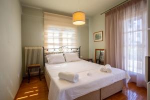 sypialnia z białym łóżkiem i ręcznikami na nim w obiekcie Τraditional fully detached villa on a luxurious hillock of Thessaloniki with its own garden also for family & wedding gatherings for 10 to 25 people only 15 minutes from airport w Salonikach