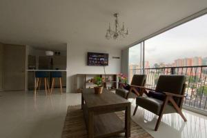 a living room with a table and chairs and a large window at Ubicación privilegiada. Todo al alcance de tu mano in Sabaneta