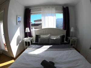a bedroom with a large bed with a large window at Casa San Tomas in Güéjar-Sierra