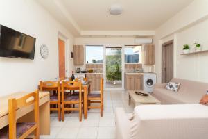 uma sala de estar com uma mesa e uma cozinha em Artemis Fani Apartments em Pastida