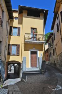 a yellow building with a balcony on a street at Casa CarMa in Porto Ceresio
