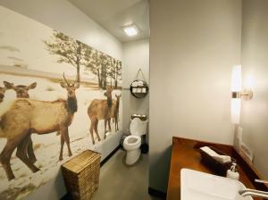 a bathroom with a painting of deer on the wall at Dreamcatcher Tipi Hotel in Gardiner +26 photos