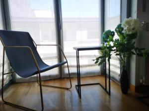 a table and a chair and a vase with flowers at Golden Vedra Residences in Pontevedra