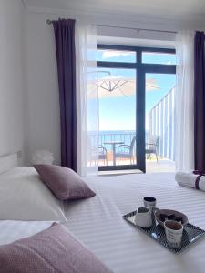 a bedroom with a bed with a view of the ocean at Apartments La Perla in Mlini