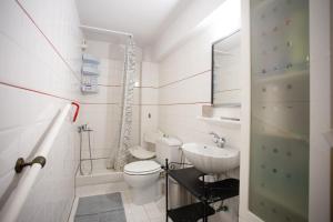 a white bathroom with a toilet and a sink at Traditional villa appartment with garden, also for gatherings ,15 minutes from Thessaloniki airport in Thessaloniki