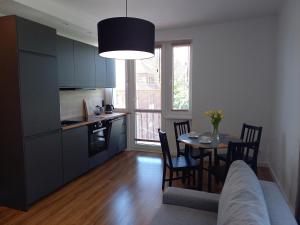 a kitchen and dining room with a table and a couch at Koszalin-Old Town Apartment in Koszalin