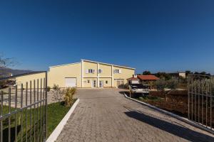 a building with a fence next to a driveway at Orange Tree Garden in Kastel Stafilic