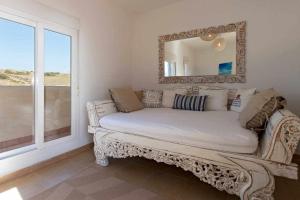 un sofá en una habitación con espejo y ventana en Tarifa Beach Rentals Aljara, en Tarifa