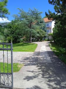 a road leading to a building with trees and grass at Mare & Bartol in Bribir