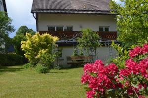 dom z różowymi kwiatami w ogrodzie w obiekcie Ferienhaus Linde am Bleßberg w mieście Schirnrod