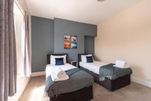 sypialnia z dwoma łóżkami z kapeluszami w obiekcie 3 Bedroom-5 Beds Newland Ave King's Palace Leisure-Contractor-Heart of Hull Amenities w mieście Hull