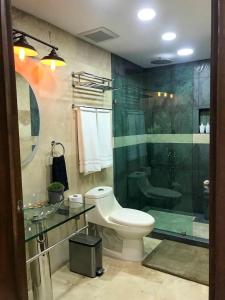 a bathroom with a toilet and a glass shower at Rio Suites in Tijuana