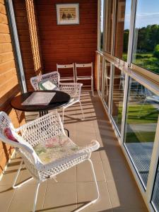 a porch with two chairs and a table and a table at Scandi FoRest in Palanga