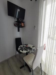 een kamer met een tafel en twee stoelen en een televisie bij Apartment Lira 2 in Mlini