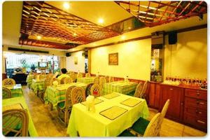 un restaurante con mesas y sillas con manteles amarillos y verdes en Wall Street Inn, Bangkok, en Bangkok